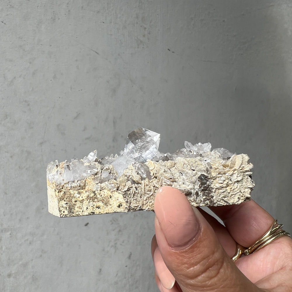 Hand holding a Double Terminated "Diamond" Quartz from Pakistan against a dark background