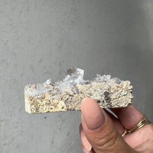 Hand holding a Double Terminated "Diamond" Quartz from Pakistan against a dark background
