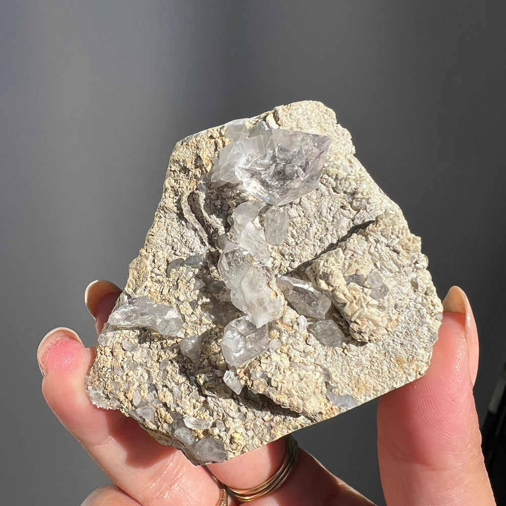 Hand holding a Double Terminated "Diamond" Quartz from Pakistan against a dark background