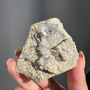 Hand holding a Double Terminated "Diamond" Quartz from Pakistan against a dark background