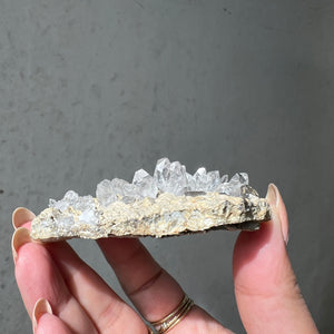 Hand holding a Double Terminated "Diamond" Quartz from Pakistan against a dark background