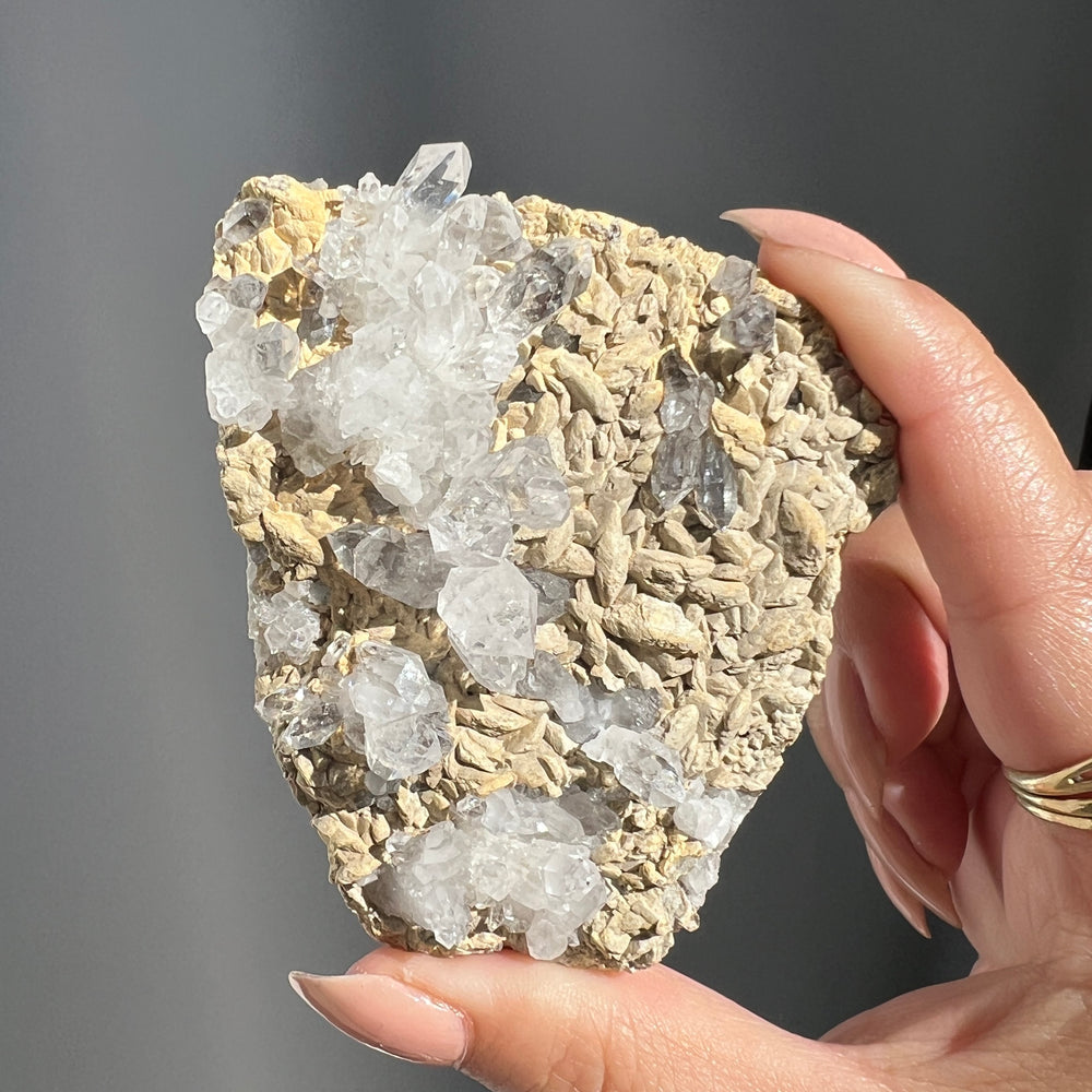 Hand holding a Double Terminated "Diamond" Quartz from Pakistan against a dark background