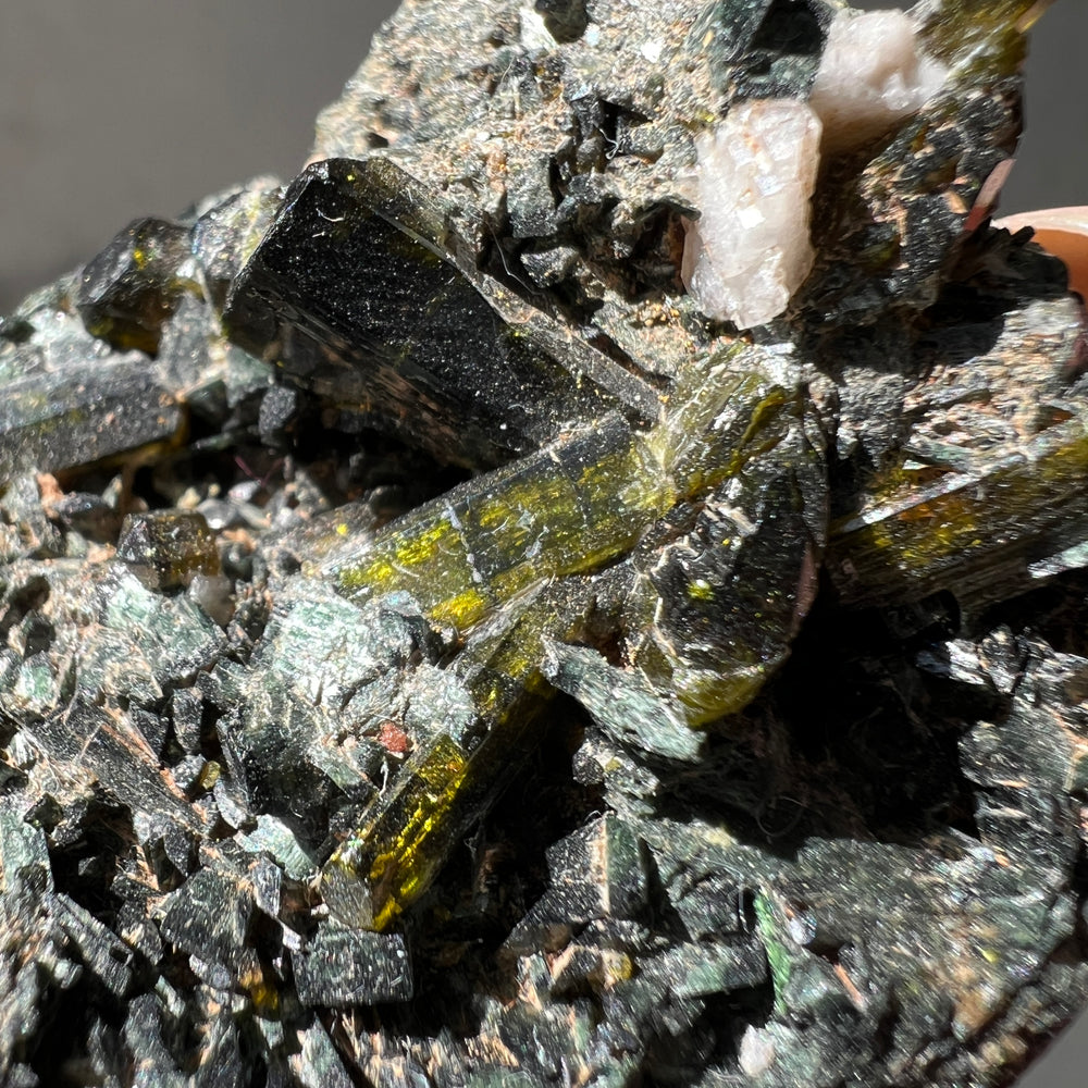  an australian epidote and albite mineral specimen against a grey background