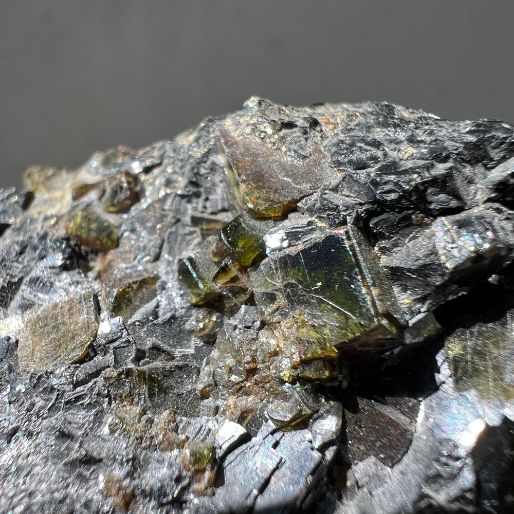  an australian epidote and albite mineral specimen against a grey background
