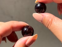 
                
                    Load and play video in Gallery viewer, video of Hands holding a pair of Almandine Garnet mini sphere meditation harmonisers against a neutral background
                
            